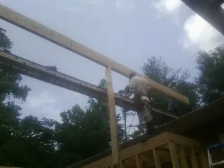 Carpenter setting a ridge beam over a new addition frame — Ice Dam Removal by Roofing Brothers in Pequea