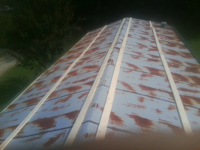 Rusted metal roof panels with new wood purlins before replacement — Storm Damage Roof Repair in Pequea by Roofing Brothers