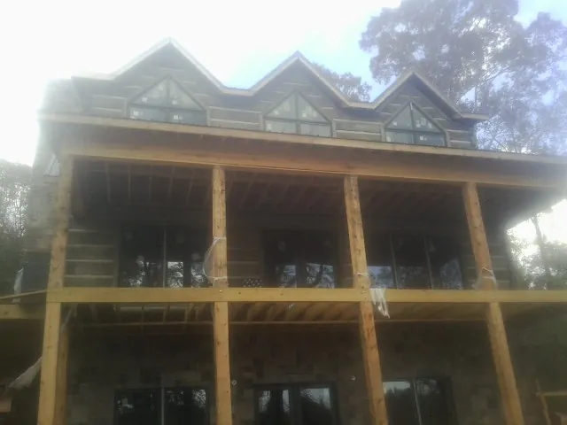 Dormers and porch framing on a large log home under construction — Roof Coating work by our crew in Pequea