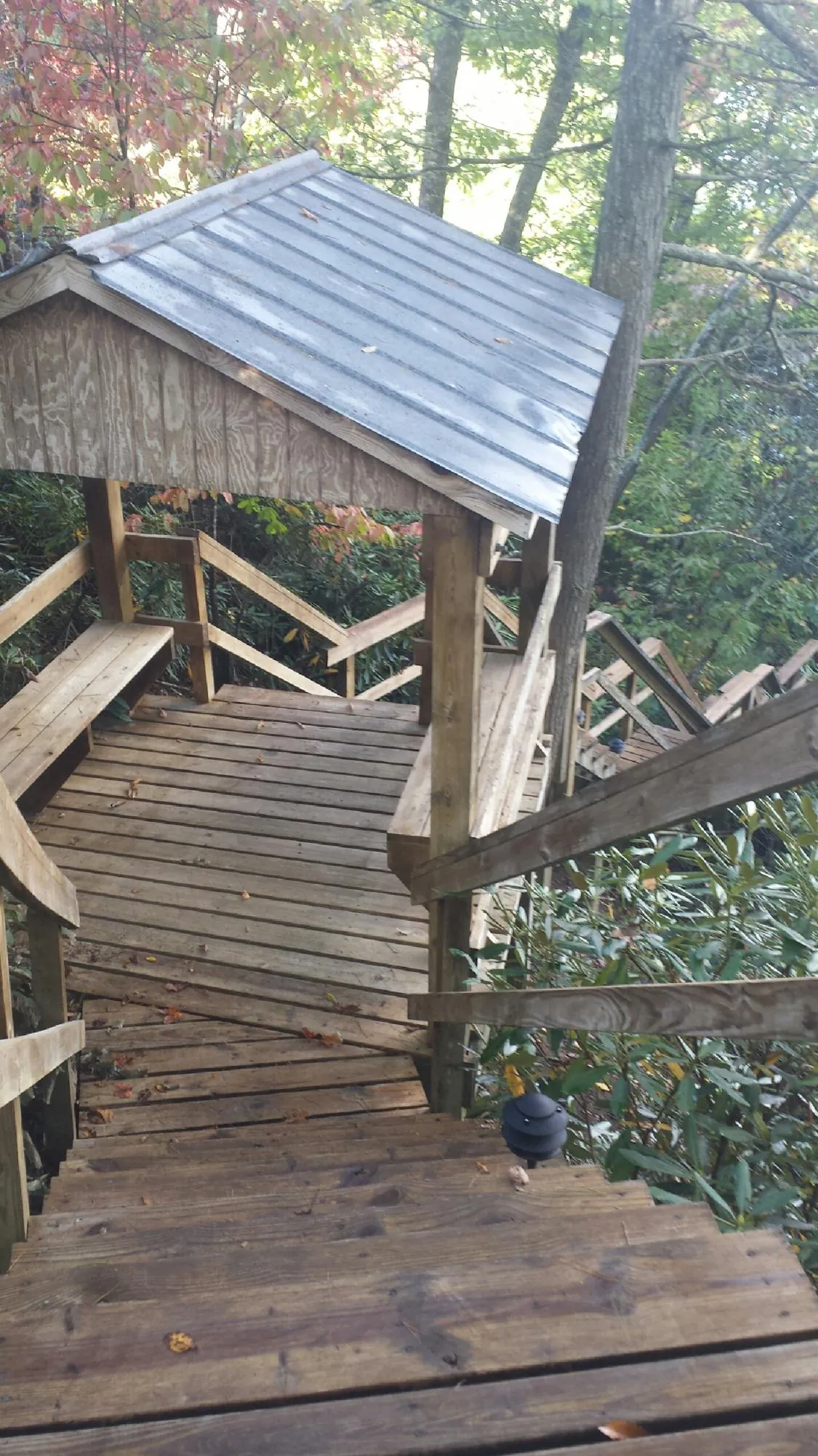 Metal roofed shelter over wooden steps on a wooded walkway — Skylight Repair & Installation work by our crew in Pequea